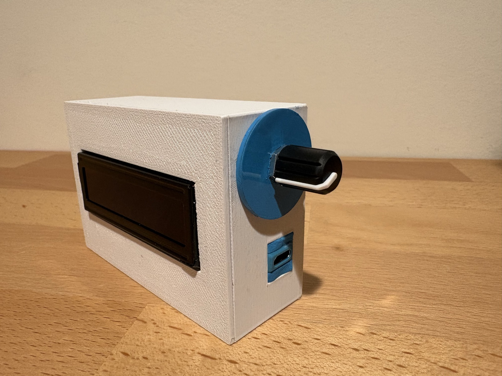 Completed Spotify Clock case with rubber knob on workbench